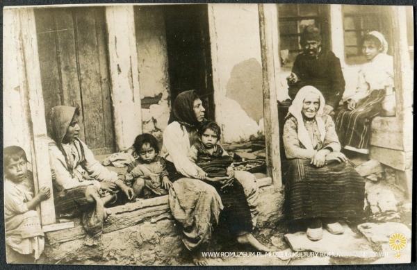Grupa Romów na progu domostwa